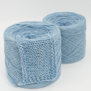 Two skeins of light blue yarn on a white background